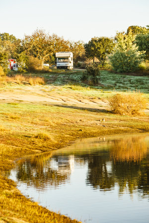 Camping on nature. Camper vehicle at lake shore. Povoa e Meadas Dam in Castelo de Vide, Alentejo Portugal. Travel in motor home.の写真素材