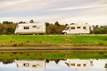 Camping on nature. Camper vehicles at lake shore reflecting in water. Povoa e Meadas Dam in Castelo...