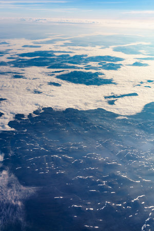 View from airplane to clouds and land. Aircraft flying over Norway Scandinavia.の写真素材