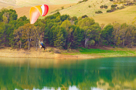 Paragliding. Paraglider flying over spanish nature landscape. Ardales Reservoir, Malaga province in...