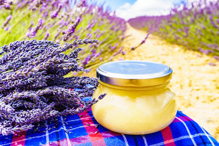 Jar with honey against fresh lavender field background. Provence in France.の写真素材