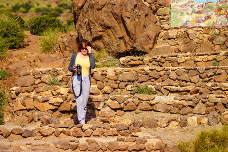 Tourist woman walking with camera, take travel picture outdoors on mediterranean nature in Spain.の写真素材