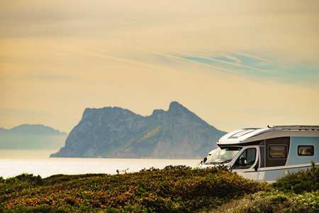 Caravan rv on mediterranean coast in Spain. Gibraltar rock view on horizon. Camping on nature. Vacation and traveling in mobile home.の写真素材