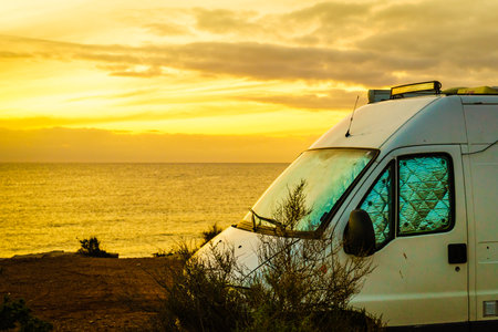 Camper van rv at sunrise on mediterranean coast Costa Calida in Murcia region, Spain. Camping on nature beach. Vacation and trip in motor home.の写真素材