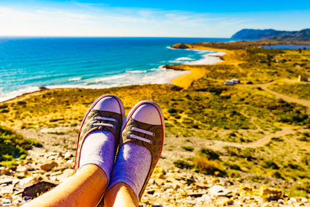 Female feet against mediterranean sea coast landscape. Murcia region, Calblanque Regional Park in Spain. Hiking, active lifestyle.の写真素材