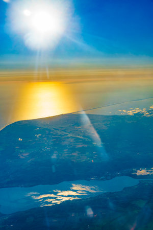 View from an airplane window to Polish coast, Baltic Sea at morning sunrise. Aircraft flying over Poland Europe.の写真素材