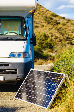 Portable solar photovoltaic panel, charging battery at camper car rv camping on spanish coast.の写真素材