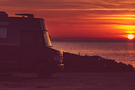 Camper rv at sunrise on mediterranean coast Costa del Sol, Andalucia Spain. Camping on nature beach. Vacation and trip in motor home.の写真素材