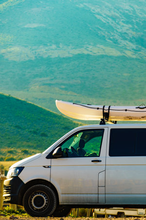 Car van with canoe on top roof against mountain nature. Active lifestyle sports concept.の写真素材