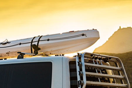 Car van with canoe on top roof against sky. Active lifestyle sports concept.の写真素材
