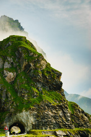 Road with old tunnel in green summer mountains, Norway. National tourist Andoya route.