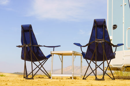 Camp equipment chairs and tables at caravan. Wild camping on nature. Holidays and traveling in motor home.の写真素材