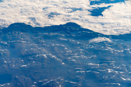 View from airplane to clouds and land. Aircraft flying over Norway Scandinavia.の写真素材