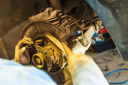 Car in service repairing. Detail of wheel assembly on automobile.の写真素材