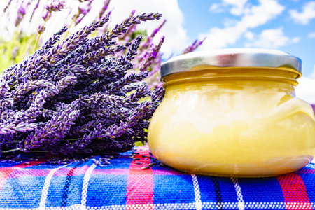 Jar with honey against fresh lavender field background. Provence in France.の写真素材