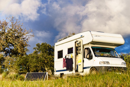 Laundry and portable solar photovoltaic panel, charging battery at camper car rv. Camping on nature.の写真素材