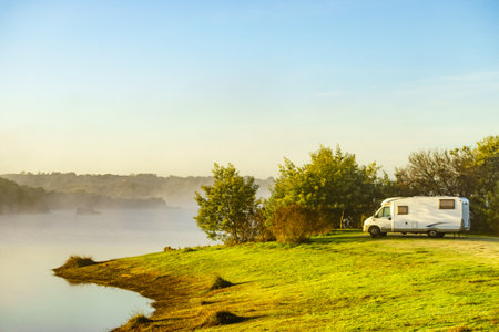 Camping on nature. Camper vehicle at lake shore. Povoa e Meadas Dam in Castelo de Vide, Alentejo Portugal. Travel in motor home.の写真素材
