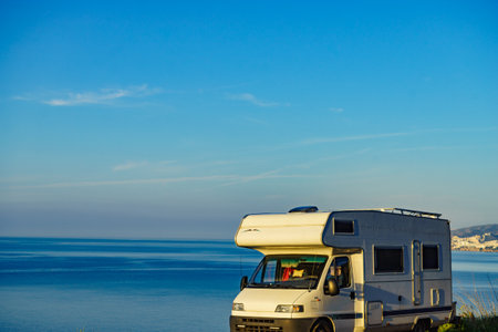 Camper rv caravan on mediterranean coast in Spain. Wild camping on sea shore. Holidays trip with motor home.の写真素材