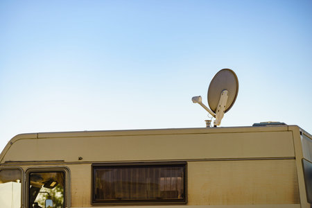 Satellite dish on roof of camper vehicle. TV connection. Travel holidays in motor home.
