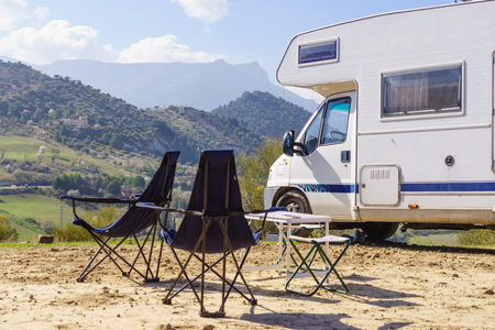 Camp equipment chairs and tables at caravan. Wild camping on nature. Holidays and traveling in motor home.の写真素材