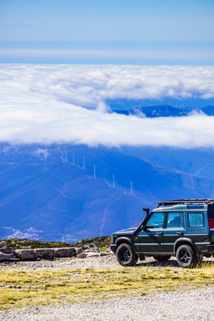 Off road vehicle above clouds in mountain nature.