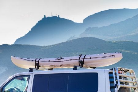 Car van with canoe on top roof against mountain nature. Cabo de Gata Nijar Natural Park, province of Almeria, Andalusia in Spain. Active lifestyle sports concept.の写真素材