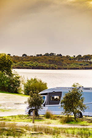 Camping on nature. Camper vehicle at lake shore. Povoa e Meadas Dam in Castelo de Vide, Alentejo Portugal. Travel in motor home.の写真素材