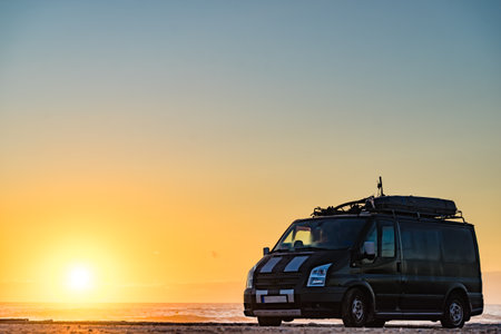 Camper van recreational vehicle at sunrise on mediterranean coast in Spain. Camping on the beach. Vacation and traveling in motor home.の写真素材