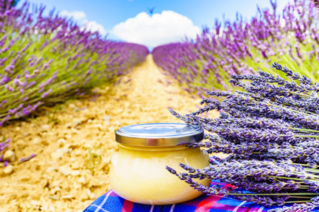 Jar with honey against fresh lavender field background. Provence in France.の写真素材