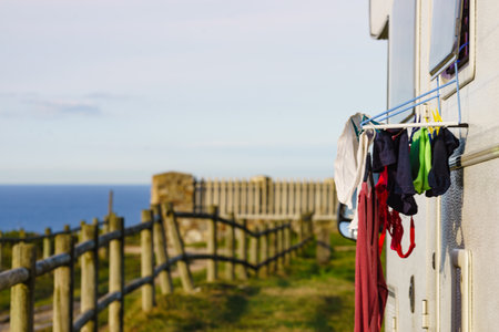 Wild camping on sea shore. Camper rv with clothes hanging to dry. Holidays with motor home.の写真素材