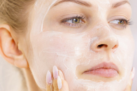 Young woman applying cream cosmetic, mask moisturizing to her face. beauty treatment. skincare.の写真素材