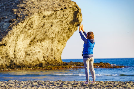 Woman walking on Monsul beach in Cabo de Gata Nijar Natural Park. Coast of Almeria. Huge lava formation as tourist attraction.の写真素材