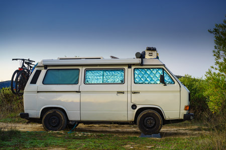 Camper van with internal thermal screen blind at window pane camping on nature in summer. Vanlife. Caravan vacation.の写真素材
