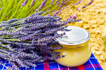Jar with honey against fresh lavender field background. Provence in France.の写真素材