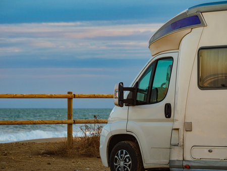 Camping on sea shore. Camper vehicle on beach, mediterranean coast in Spain.の写真素材