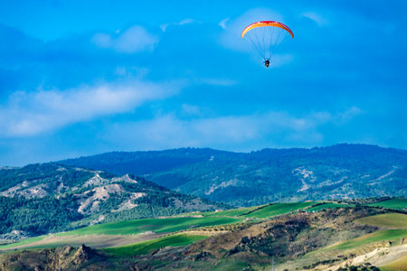 Paragliding. Paraglider flying over spanish nature landscape. Ardales Reservoir, Malaga province in Andalusia, Spain.の写真素材