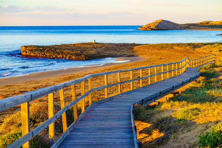 Beach seashore with wooden path to sea water. Cala Magre in Calblanque Regional Park, Murcia region Spain.の写真素材