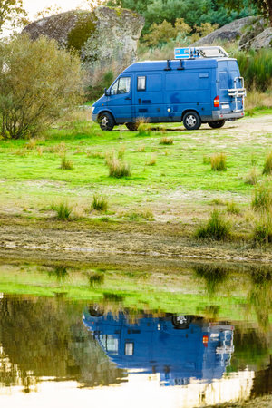 Camping on nature. Camper van at lake shore. Povoa e Meadas Dam in Castelo de Vide, Alentejo Portugal. Travel in motor home.の写真素材