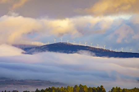 Morning view. Fog over valley and wind turbines farm on hill covered with clouds. Aguilar de Campoo in province of Palencia, Castile and Leon community, northern Spain.の写真素材