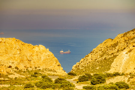 Rocky coastal landscape with ship on sea. View from Mesa Roldan. Cabo de Gata Nijar, coast of Almeria, Spain.の写真素材