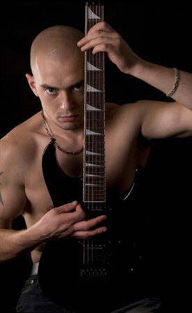 Portrait of the guitarist on a black backgroundの写真素材