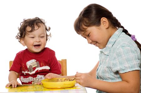 The big sister feeds the younger brother with a porridge.の写真素材