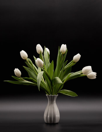 bouquet of white tulips in a vase on a dark background with perspectiveの写真素材