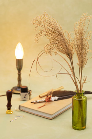bouquet of flowers dried in a vase with lamp on an olive background in boho styleの写真素材