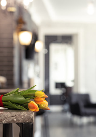 a bouquet of tulips is on the table room in bokehの写真素材