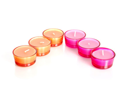 Pink and orange candles in glass isolated on whiteの写真素材