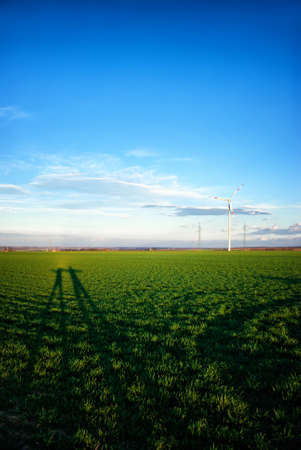 Landscape with wind turbines and shadows of peopleの写真素材