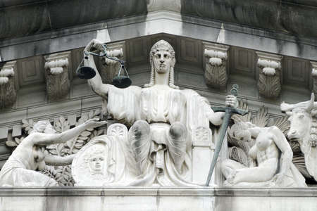 The central figure in the tympanum is that of Justice, with a figure immediately to its left representing the lost soul begging for protection from it.  Pediment sculpture of the Old Supreme Court, City hall Singaporeの写真素材