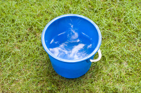 Collecting rain water in a blue pailの写真素材