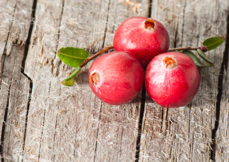 Cranberries on an old wooden board.の写真素材